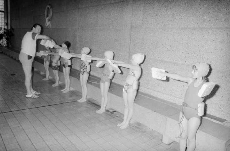 Swimming lessons of the class steps 2 and 3 in a swimming hall in Berlin, the former capital of the GDR, German democratic republic