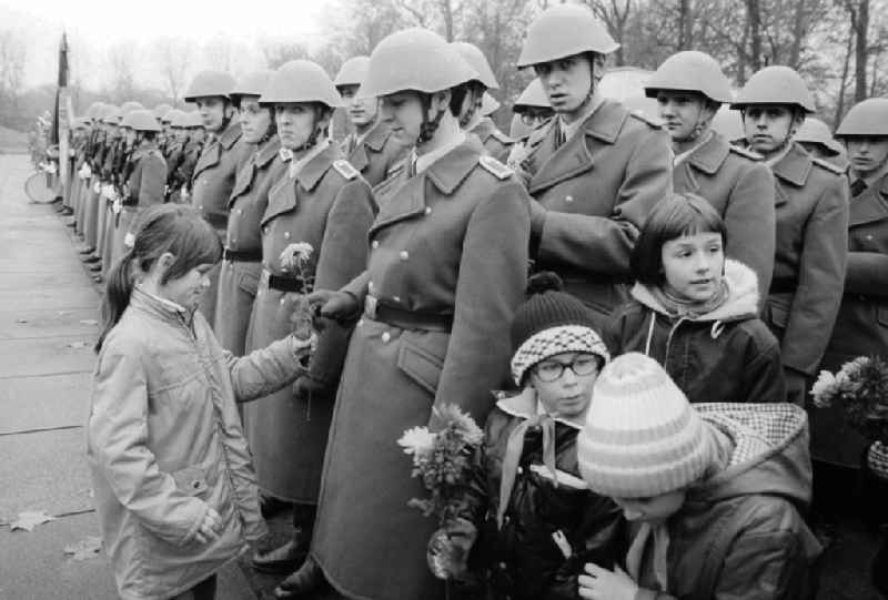 Swearing of the national police (VP) in the Soviet monument in the Treptower park in Berlin, the former capital of the GDR, German democratic republic. Young pioneers to overabundant flowers