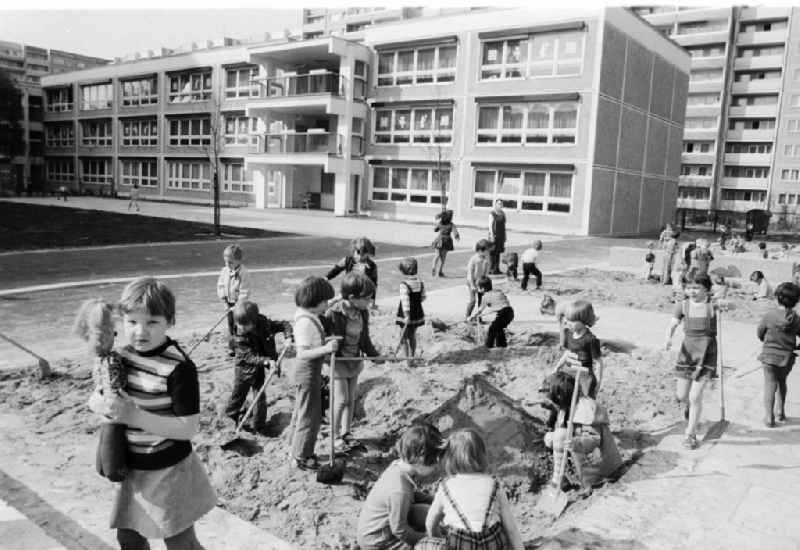Children play in the sandpit in the child cooked and build a sand castle in Berlin, the former capital of the GDR, German democratic republic