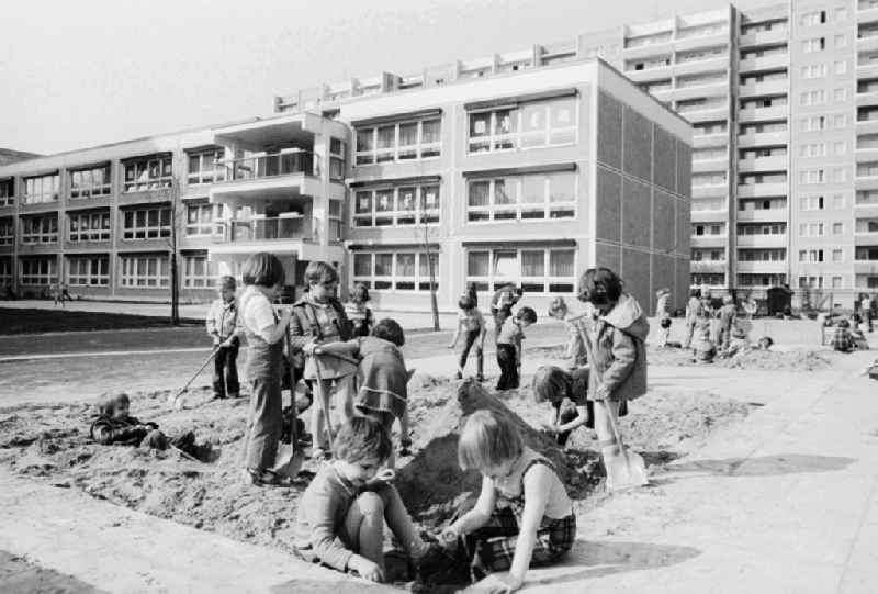 Children play in the sandpit in the child cooked and build a sand castle in Berlin, the former capital of the GDR, German democratic republic