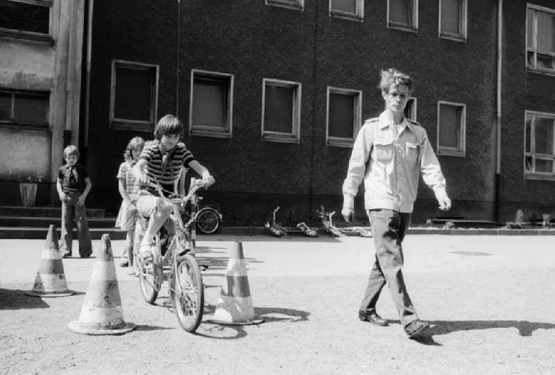 Schoolgirls and schoolboys with the road safety education in the holiday's plays / hoard on the summer holidays in Berlin, the former capital of the GDR, German democratic republic. The holiday's plays were intended mainly for schoolboys first to the fourth class