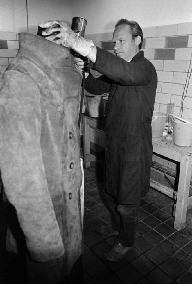 A worker in the VEB united laundrys Berlin Rewatex with clean of a coat in Berlin, the former capital of the GDR, German democratic republic