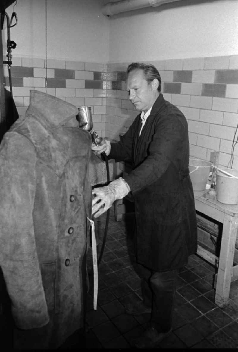 A worker in the VEB united laundrys Berlin Rewatex with clean of a coat in Berlin, the former capital of the GDR, German democratic republic