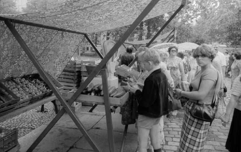Customers in a fruit state and vegetable state at the weekly market on the place Askona in Berlin, the former capital of the GDR, German democratic republic