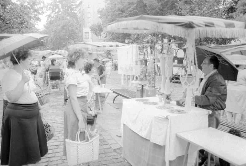 Customers in a sales state for macrame products at the weekly market on the place Askona in Berlin, the former capital of the GDR, German democratic republic