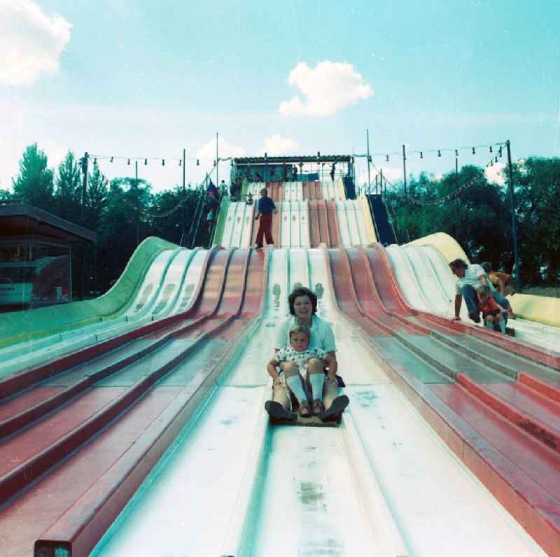 Visitor of the cultural park Plaenterwald on the gigantic children's slide in Berlin, the former capital of the GDR, German democratic republic
