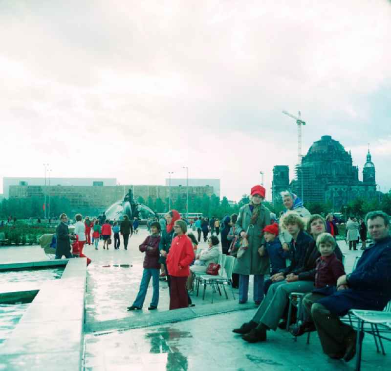 Tourists sit on a park bench in the centre of Berlin, the former capital of the GDR, German Democratic Republic