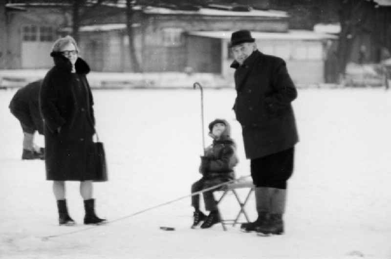 Grandparents with their grandson ice-fishing on a lake in Berlin, the former capital of the GDR, German Democratic Republic