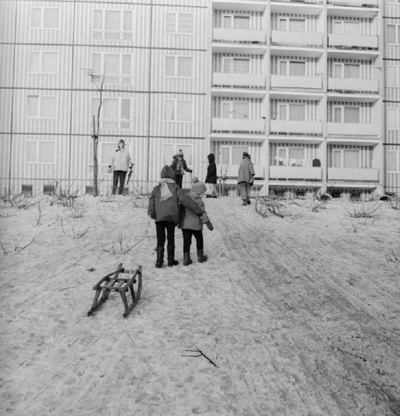 Children with sledges on a toboggan hill in a residential area in Berlin, the former capital of the GDR, German Democratic Republic