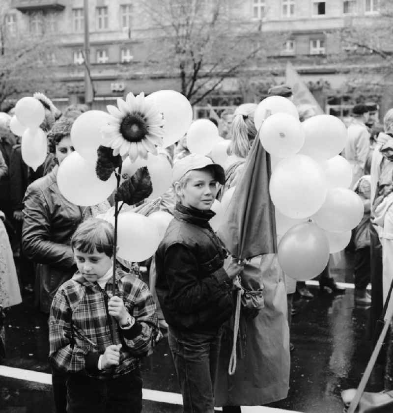 Enthusiastic GDR citizens with children and family passing by the VIP tribune on 1 May in Berlin, the former capital of the GDR, German Democratic Republic