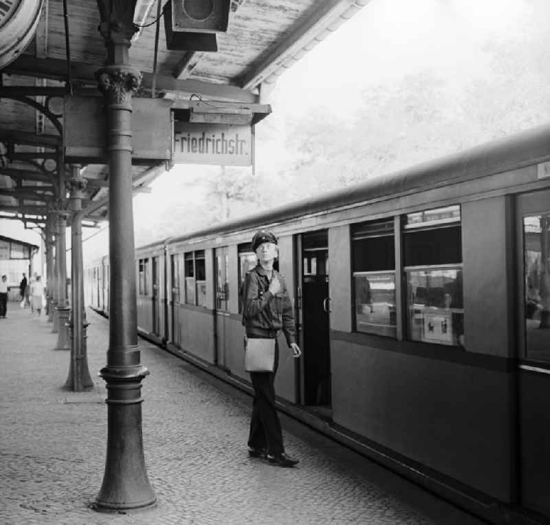 Schaffner on arrival/departure of an S-Bahn in the direction of Friedrichstrasse at Schoeneweide station in Berlin, the former capital of the GDR, German Democratic Republic
