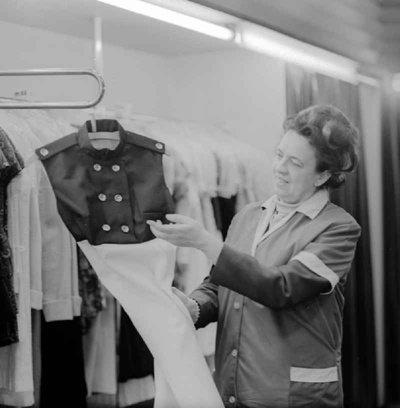 Saleswoman with smock apron in the Fashion House of Youth on the Gertraudenstrasse in Berlin, the former capital of the GDR, German Democratic Republic