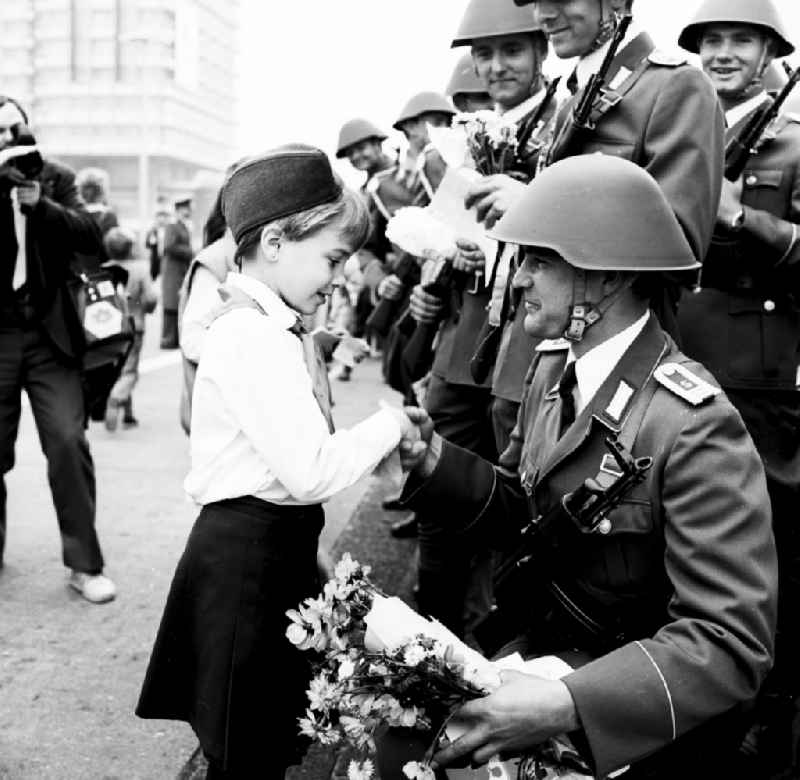 Young pioneers present NVA soldiers with flowers and scarves in Berlin, the former capital of the GDR, German Democratic Republic