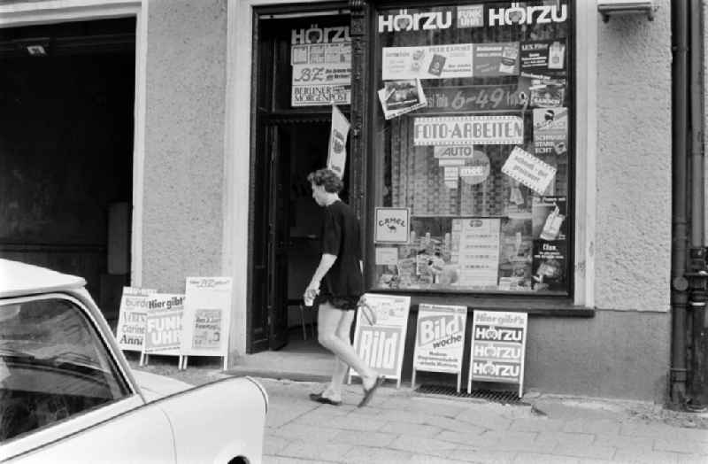 Exhibitors in front of a newsstand at the Karl-Marx-Allee in Berlin - Friedrichshain advertise for newspapers and magazines like 'Bild', 'Bild-Woche', 'Hoerzu', 'Funkuhr', 'Burda', 'BZ' and 'Berliner Morgenpost '