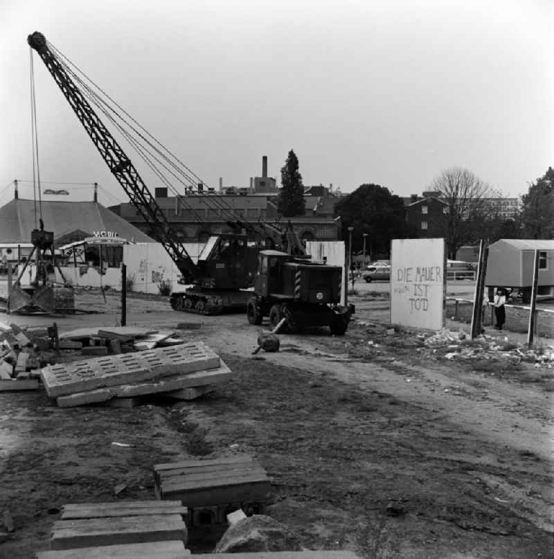 Dismantling of the Berlin Wall at Michaelkirchplatz between Berlin - Kreuzberg and Berlin - Mitte. 'The Wall is dead' stands on a wall segment. On the left the tent of the Variete mobil
