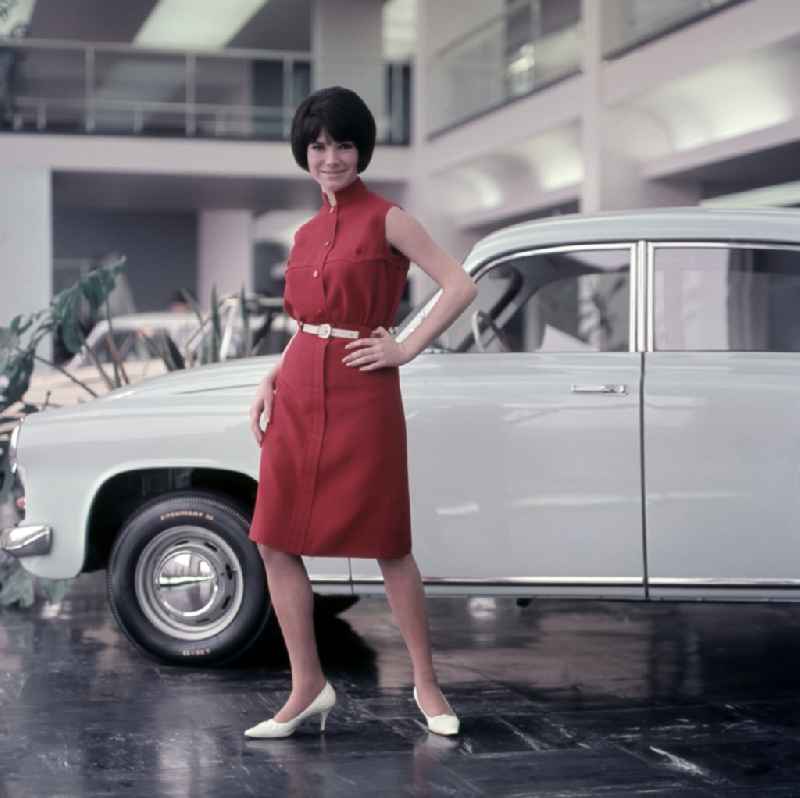 Young woman presents current women's fashion collection in front of a Trabant P5