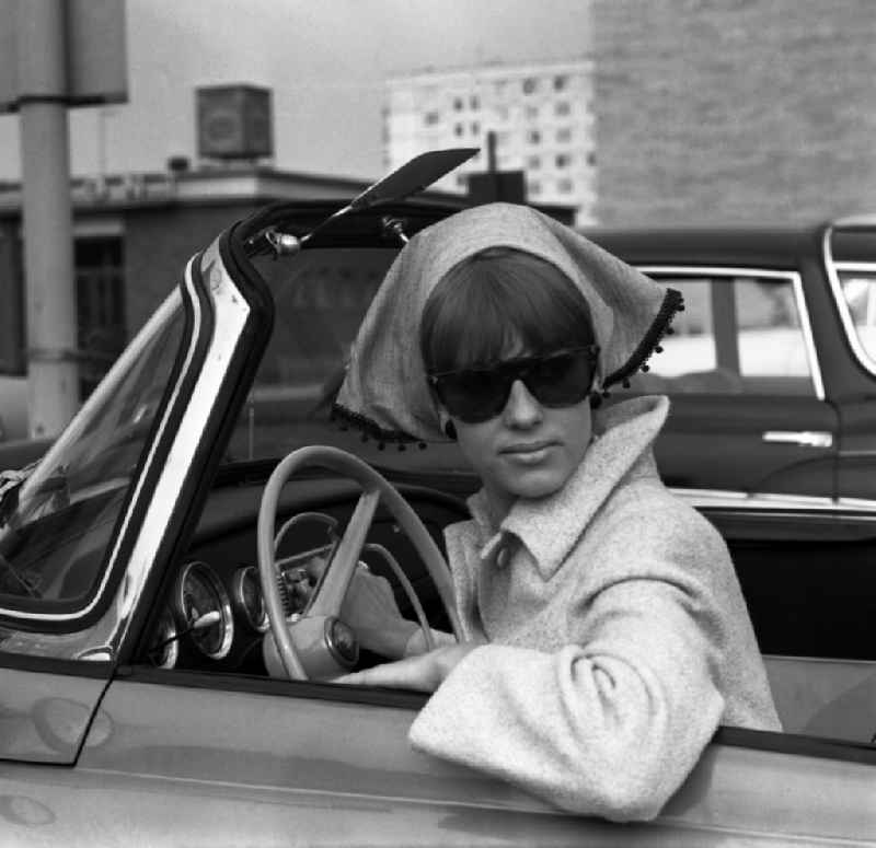 Young woman as a driver at the steering wheel of a car SKODA FELICIA Cabriolet in Berlin, the former capital of the GDR, German Democratic Republic