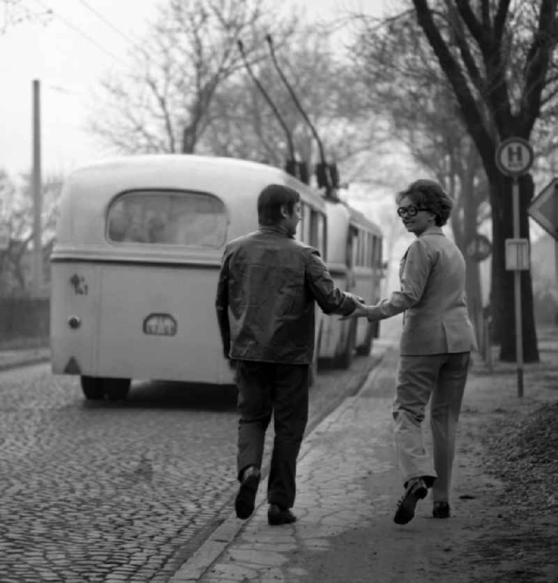 Passengers getting on and off at a bus stop trolleybus in the district Friedrichshain in Berlin, the former capital of the GDR, German Democratic Republic