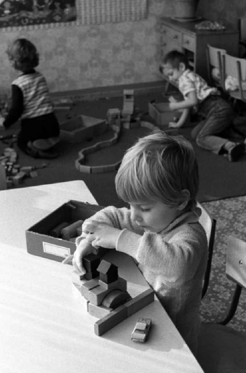 Games and fun with toddlers in kindergarten playing with wooden blocks in Berlin Eastberlin, the former capital of the GDR, German Democratic Republic