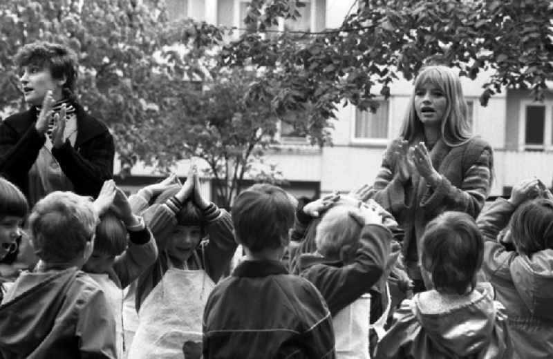 Games and fun with toddlers in kindergarten with instructions for gardening in the school garden in Berlin Eastberlin, the former capital of the GDR, German Democratic Republic