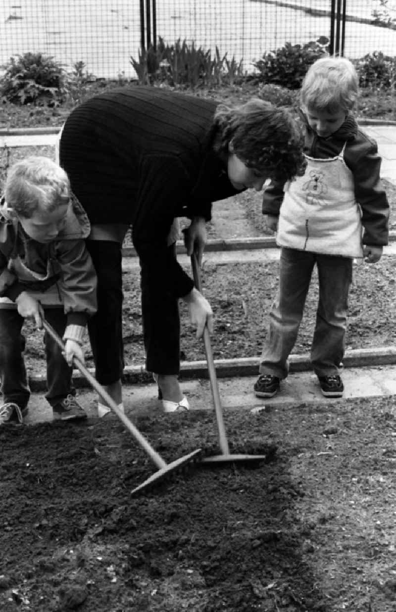 Games and fun with toddlers in kindergarten with instructions for gardening in the school garden in Berlin Eastberlin, the former capital of the GDR, German Democratic Republic