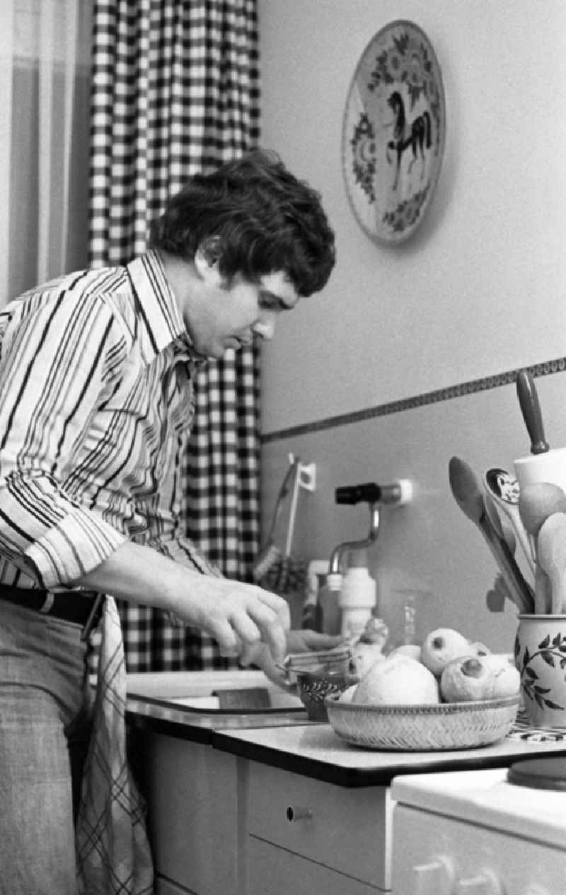 Portrait shot of the singer and musician Frank Schoebel in the kitchen of his apartment doing housework in the district Mitte in Berlin Eastberlin, the former capital of the GDR, German Democratic Republic