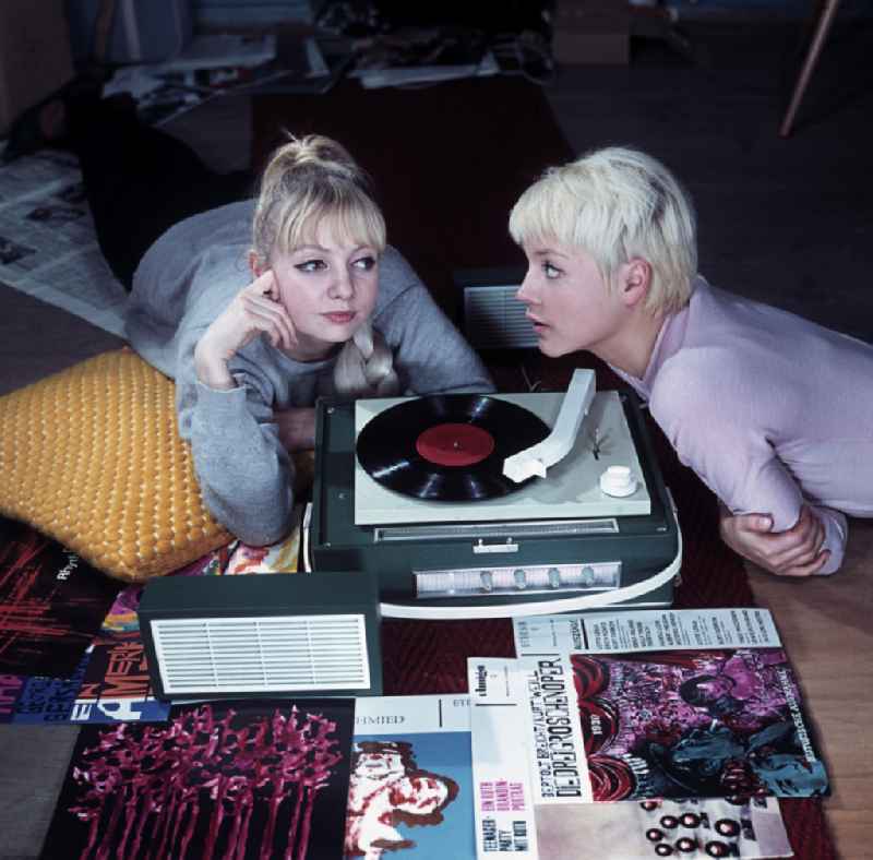 Advertising shot for the Ziphona P 1229 portable record player from VEB RFT Phonotechnik Zittau in Berlin Eastberlin on the territory of the former GDR, German Democratic Republic. Two young women listening to a vinyle record together