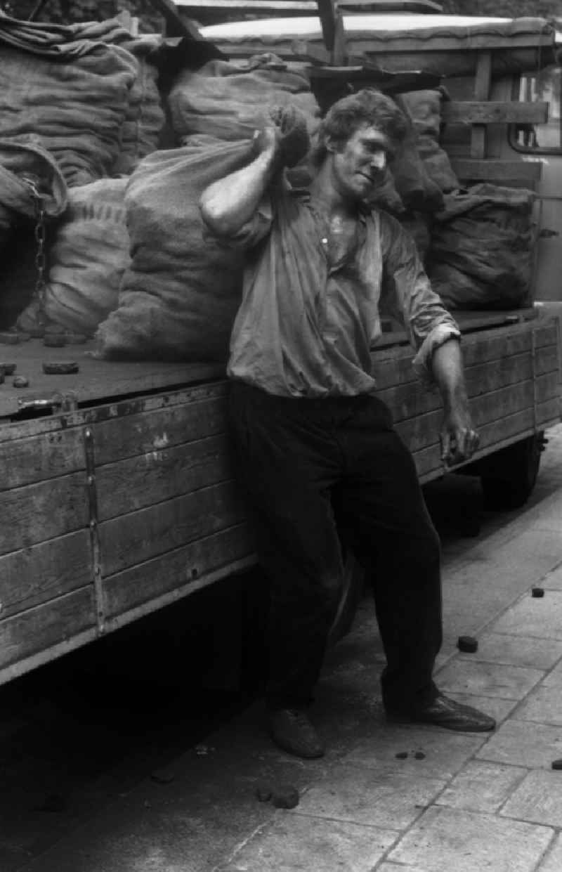 Worker carries a sack of carbon in the district Mitte in Berlin Eastberlin on the territory of the former GDR, German Democratic Republic
