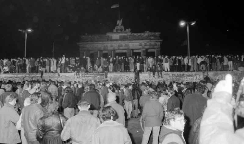 Passers-by and citizens of both parts of the city peacefully conquer the fortifications and border security structures in front of the Brandenburg Gate in the district of Mitte in Berlin East Berlin on the territory of the former GDR, German Democratic Republic