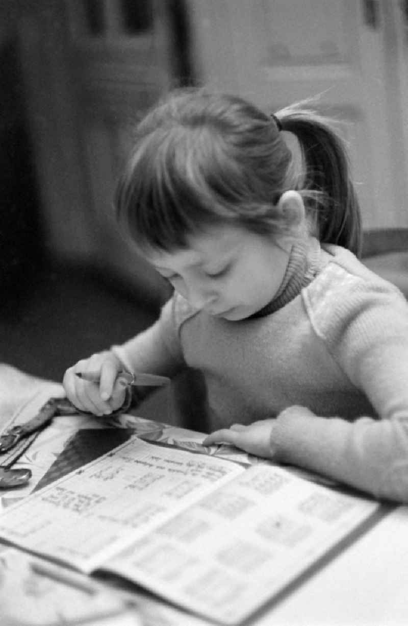 A young girl is doing her homework in Berlin Eastberlin on the territory of the former GDR, German Democratic Republic