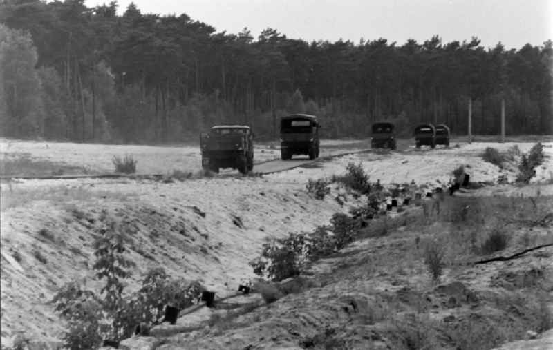 Lorries on the patrol route of the dismantled and dismantled border fortifications and wall in the former blocking strip of the state border on a camp site of the border troops in the district of Steinstuecken in Berlin on the territory of the former GDR, German Democratic Republic