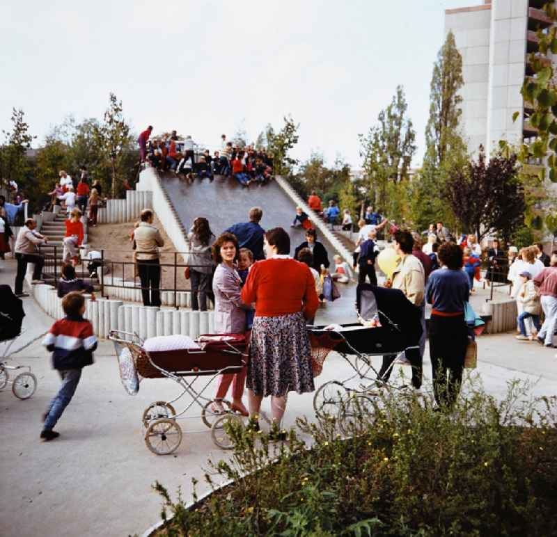Children playing on a big slide in the playground in the residential area and park area Ernst-Thaelmann-Park Prenzlauer Berg in Berlin Eastberlin on the territory of the former GDR, German Democratic Republic