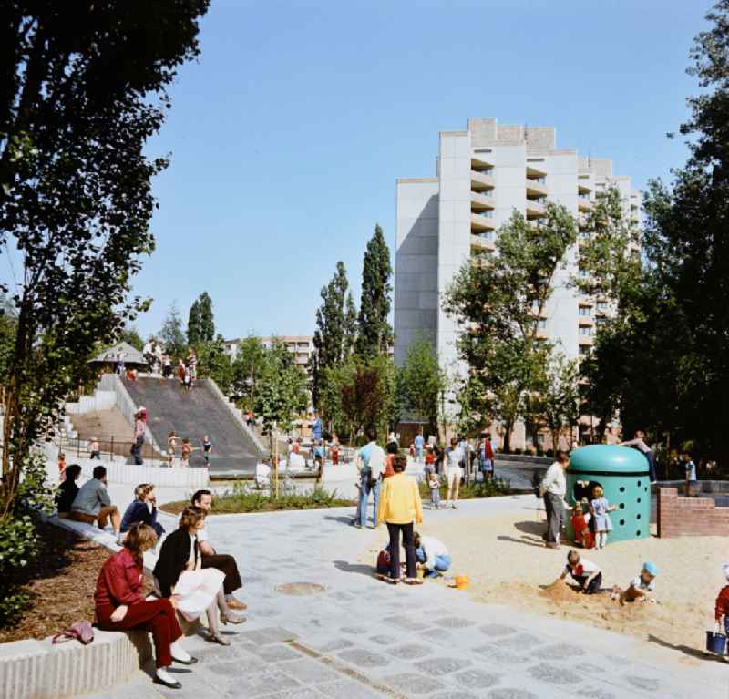 Children playing on a playground with large slide and climbing dome in the residential area and park area Ernst-Thaelmann-Park Prenzlauer Berg in Berlin Eastberlin on the territory of the former GDR, German Democratic Republic