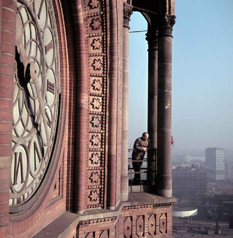 Man on the gallery of the tower at the building of the city hall of the city administration with the face of the tower clock of the Red City Hall in the district Mitte in Berlin East Berlin in the area of the former GDR, German Democratic Republic