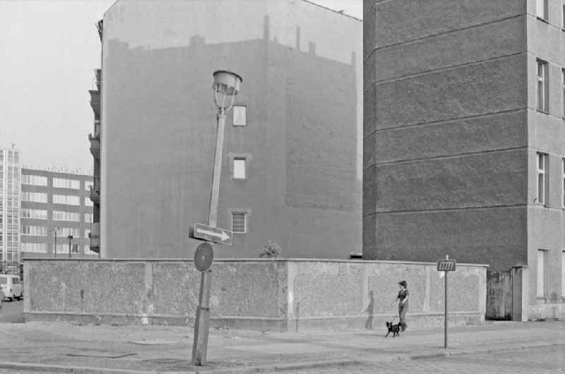 Pedestrians and passers-by in traffic mit Hund an einer schiefen Strassenlaterne on street Kadiner Strasse in the district Friedrichshain in Berlin Eastberlin on the territory of the former GDR, German Democratic Republic