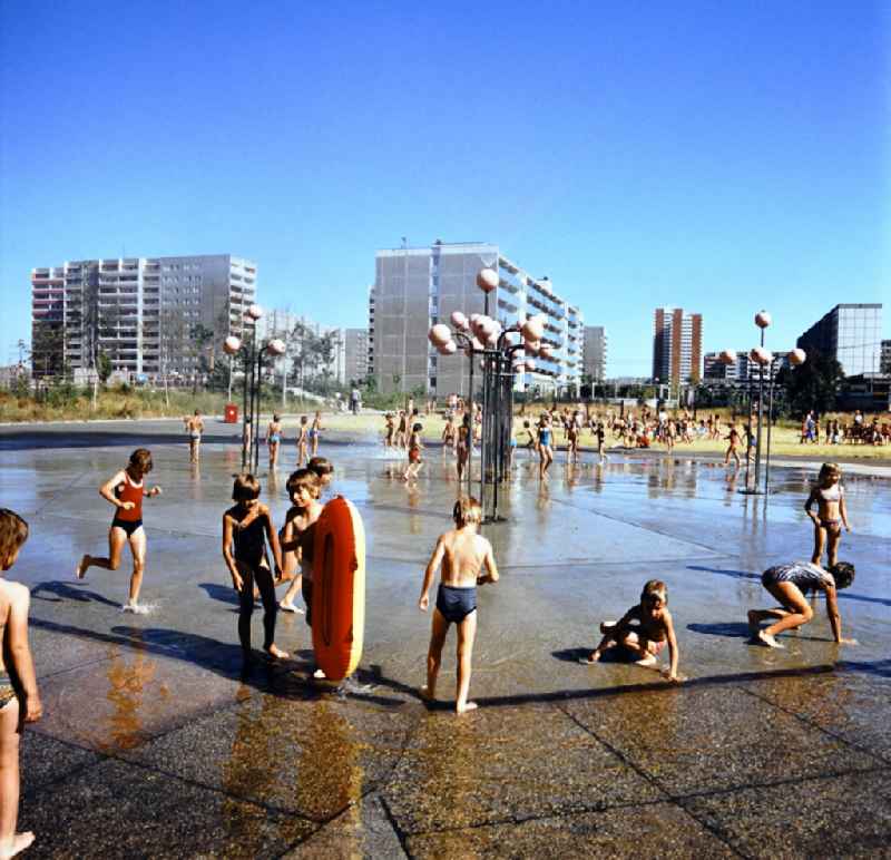 Children play on a water playground in the Marzahn residential area in Berlin Eastberlin on the territory of the former GDR, German Democratic Republic