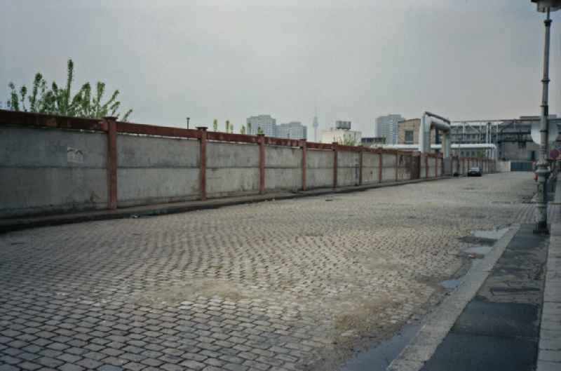 Road traffic and road conditions on a cobblestone street on an industrial area wall on Warschauer Strasse in the Friedrichshain district of Berlin East Berlin on the territory of the former GDR, German Democratic Republic