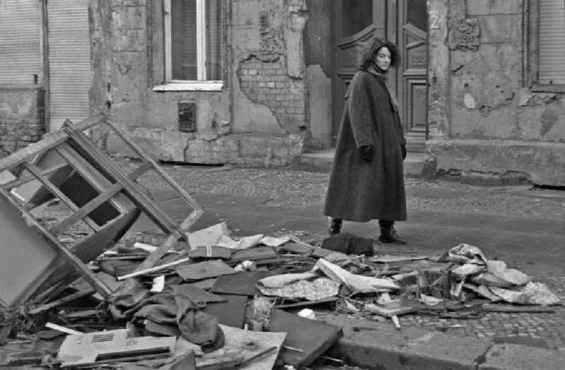 Fashion and clothing of street passers-by in front of street garbage piles on street Schreinerstrasse in the district Friedrichshain in Berlin Eastberlin on the territory of the former GDR, German Democratic Republic