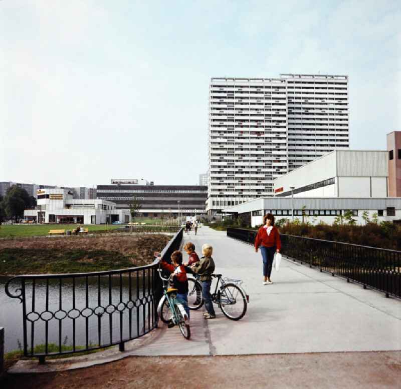 Fennpful park in the Lichtenberg district of Eastberlin in the territory of the former GDR, German Democratic Republic. View over the Fennpfuhl Bridge to the lake terraces, consumer department store, apartment buildings and sports hall