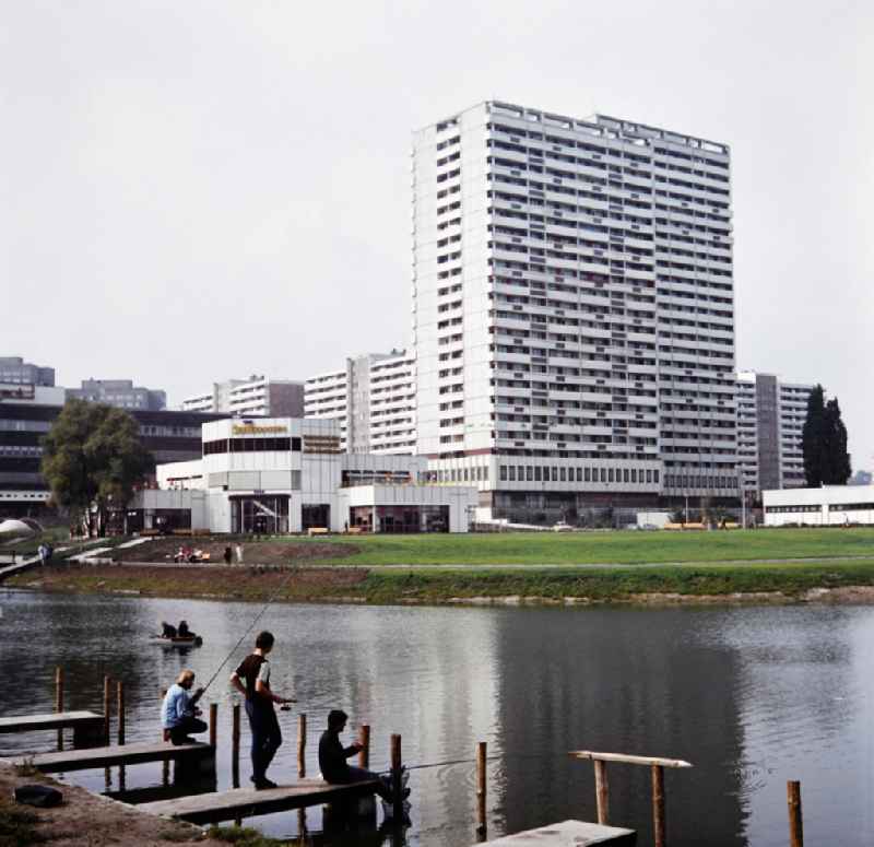 Fennpful park in the Lichtenberg district of Eastberlin in the territory of the former GDR, German Democratic Republic. View over angler at the lake, the lake terraces, the consumer department store and apartment buildings