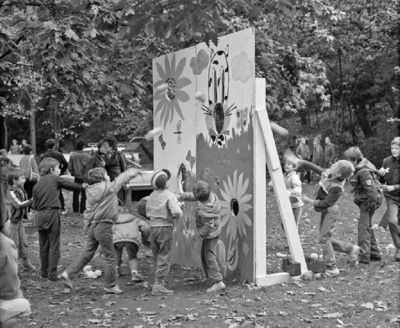 Children and young people throw balls through a partition on a playground on the occasion of the district festival at Weberwiese in the Friedrichshain district of Berlin East Berlin in the area of ??the former GDR, German Democratic Republic
