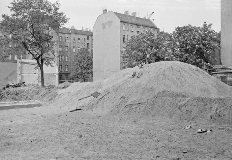 Fun and games for children and teenagers on a heap of sand on a construction site on street Corinthstrasse in Berlin Eastberlin on the territory of the former GDR, German Democratic Republic