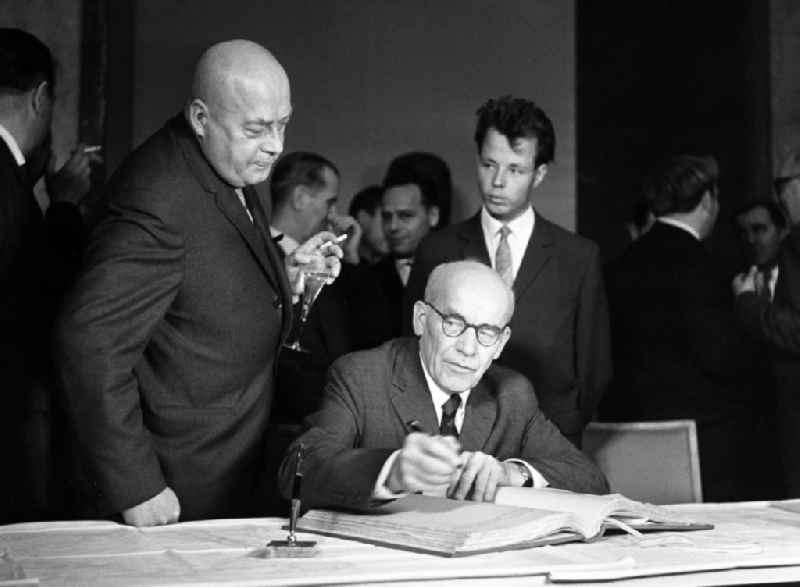 During his state visit, Wladyslaw Gomulka signs his name in the Golden Book of the city of Berlin under the gaze of Jozef Cyrankiewicz (second from left), on the territory of the former GDR, German Democratic Republic