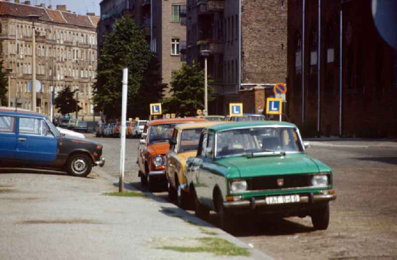 Cars from a driving school are parked on a street in Berlin in the area of the former GDR, German Democratic Republic