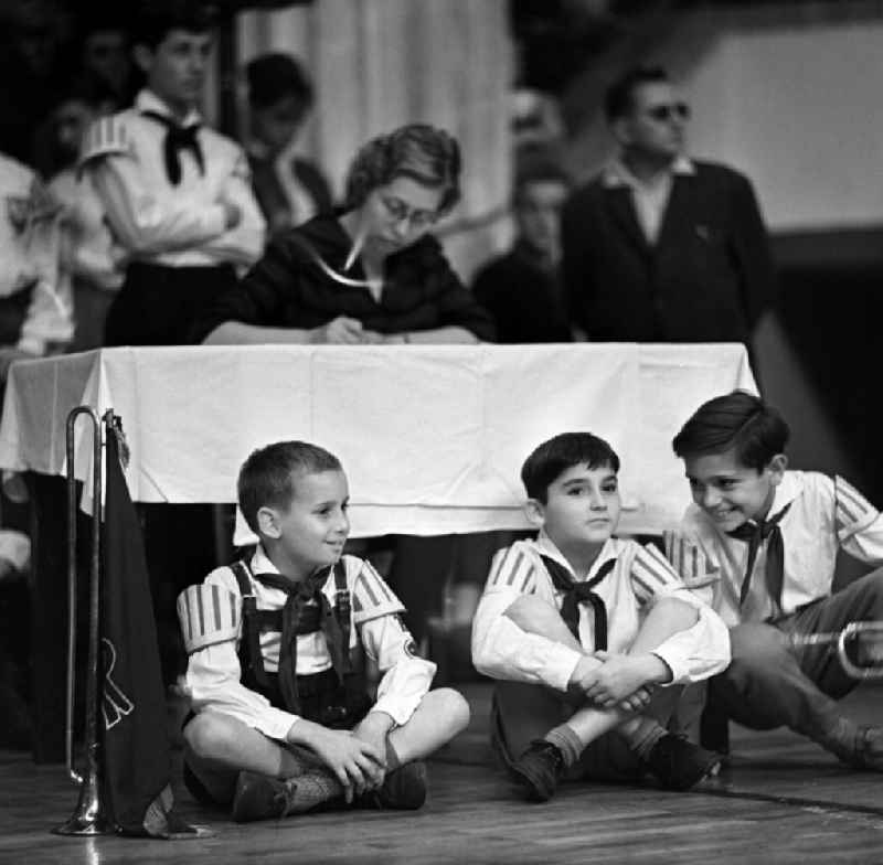 Young pioneers sit on the floor of the FDJ's VIIth Parliament in Berlin-Mitte in the area of the former GDR, German Democratic Republic