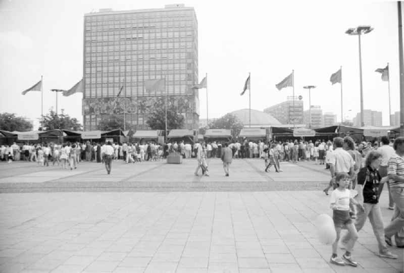 Festively decorated city on the occasion of the National Youth Festival in Berlin-Mitte on the territory of the former GDR, German Democratic Republic. Various stalls on Alexanderplatz. Flags fly on the poles in front of the 'Haus des Lehrers' HdL and the congress hall
