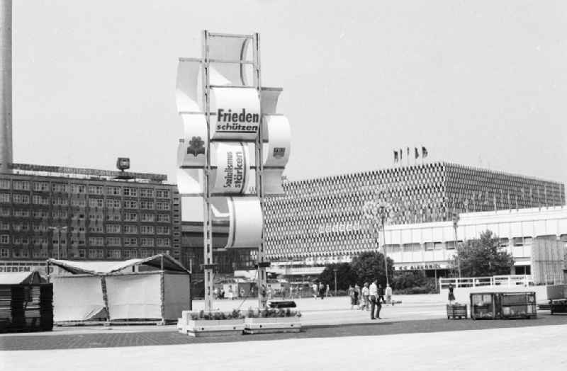 Festively decorated city on the occasion of the National Youth Festival in Berlin-Mitte on the territory of the former GDR, German Democratic Republic. At Alexanderplatz, a banner reads 'Frieden schuetzen Sozialismus staerken', and in the background is the Centrum Warenhaus