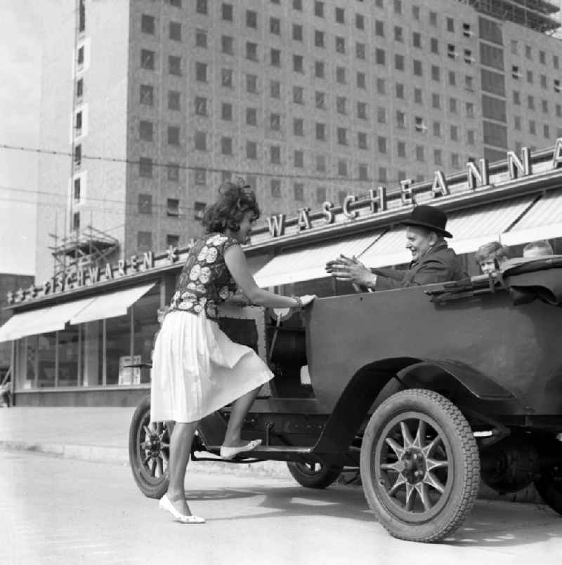 On Stalinallee, today Karl-Marx-Allee, a woman gets into a vintage F5 car from the automobile manufacturer MAF in Berlin on the territory of the former GDR, German Democratic Republic