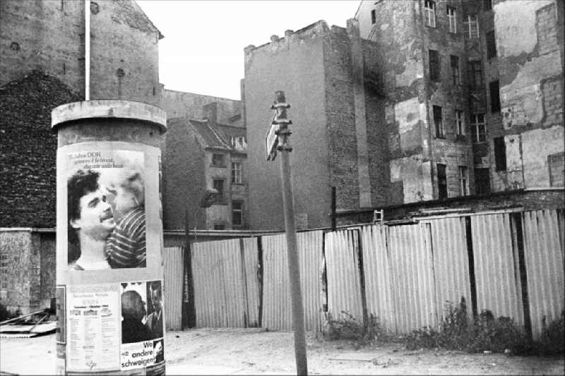 Advertising as a contrast to the dilapidated reality in the old residential area on the Scheunenviertel on an advertising pillar on a sidewalk on Max-Beer-Strasse in the Mitte district of Berlin East Berlin in the area of the former GDR, German Democratic Republic