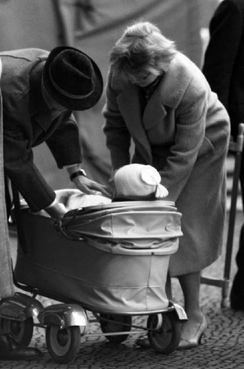 Parents care for their child in a stroller in East Berlin in the territory of the former GDR, German Democratic Republic